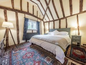 a bedroom with a large bed in a room with wooden ceilings at Dukes Lodge in Kersey