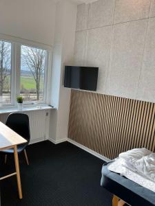 Habitación con cama y TV en la pared. en rooms for rent Andersen Invest, en Skjern