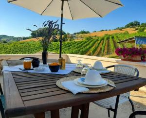 uma mesa de madeira com pratos de comida e um guarda-chuva em Casa Vacanze La Vecchia Fonte em Monteprandone