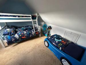 a bedroom with a bed and a bunk bed with a toy car at Fun family beach house! in Lessingham