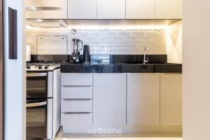 a kitchen with white cabinets and a stove top oven at Excelente apt em Maceio/AL 850m da praia ADV306 in Maceió
