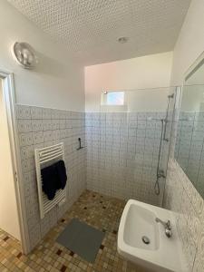 een badkamer met een wastafel en een douche bij La Tranche Cozy Stay! in La Tranche-sur-Mer