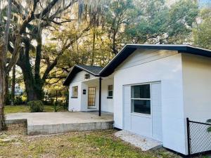 a small white garage with a door in a yard at Country Welcome in Micanopy