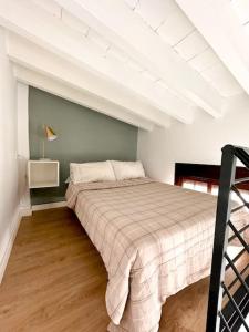 een slaapkamer met een bed in een witte kamer bij Ático Duplex Triana , Sevilla in Sevilla