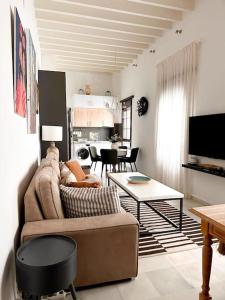 een woonkamer met een bank en een tafel bij Ático Duplex Triana , Sevilla in Sevilla