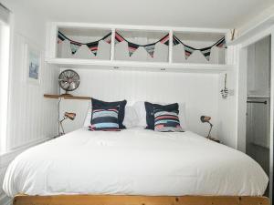 a bedroom with a white bed with two pillows at Victoria Cottage in St. Agnes