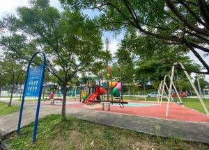 um parque com um parque infantil com escorrega e baloiços em Ratu Homestay em Kuala Selangor