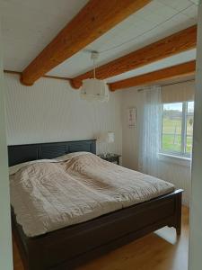 um quarto com uma cama e uma janela em Fårgården Åsebol em Gårdsjö