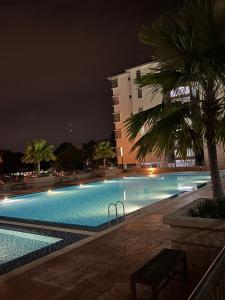 uma grande piscina à noite com um edifício em Ratu Homestay em Kuala Selangor
