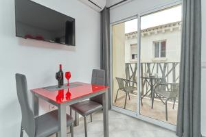 a red table and chairs in a room with a balcony at Nerja Boutique 102 Deluxe in Nerja