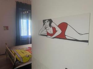 a painting of a woman sitting on a wall next to a bed at Be Your Home - Lupen III in Civitavecchia