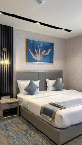 a bedroom with two beds and a painting on the wall at Niyama Hotel in Umm Lujj