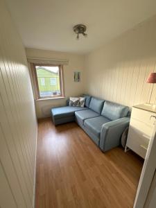 a living room with a blue couch and a window at House close to Ålesund center in Ålesund