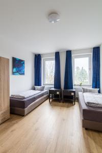 a bedroom with two beds and blue curtains at Moderne Monteurwohnung in Leipzig Nord in Leipzig