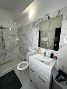 W łazience znajduje się umywalka, toaleta i lustro. w obiekcie Airport17 B&B w mieście Vecsés