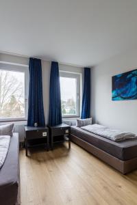 a bedroom with two beds and two windows at Moderne Monteurwohnung in Leipzig Nord in Leipzig