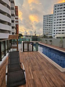 a balcony with a pool and a bench on a building at Ap. Novo Maceió - praia de Ponta verde in Maceió