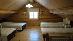 um quarto com duas camas num chalé de madeira em Fårgården Åsebol em Gårdsjö