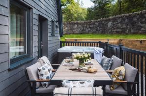 a patio with a table and chairs on a deck at Ardlui Retreat Lodge 1 in Arrochar