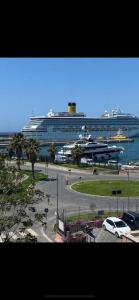 a cruise ship in the water with a car parked in a parking lot at Be Your Home - Lupen III in Civitavecchia