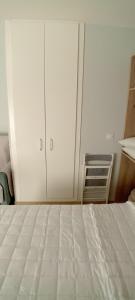 a bedroom with a white bed and white cabinets at Apartamento La Fuente 27 in Tomares