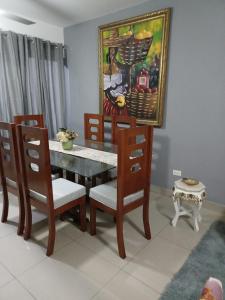 mesa de comedor y sillas con una pintura en la pared en Hermosa villa en punta cana, en Punta Cana