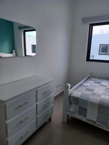 1 dormitorio con 1 cama y vestidor con espejo en Hermosa villa en punta cana, en Punta Cana