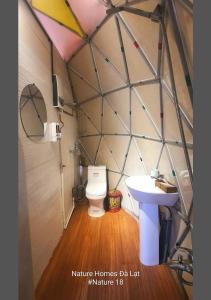 La petite salle de bains est pourvue de toilettes et d'un lavabo. dans l'établissement Nature Homes Đà Lạt, à Đà Lạt