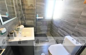 ein Badezimmer mit einer weißen Toilette und einem Waschbecken in der Unterkunft 645 Águila Apartamentos - Vista al mar - Cerca de tren, restaurantes, tiendas - PLAYA A 10 MIN CAMINANDO in Benalmádena