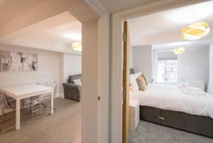 a bedroom with a bed and a table and a couch at Modern,central 1 bedroom flat in Brentwood