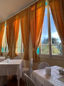 un restaurant avec deux tables et une grande fenêtre dans l'établissement Hotel Petit Royal, à Ospedaletti