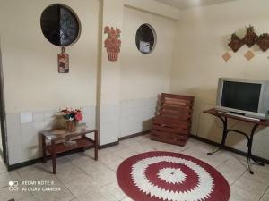 un soggiorno con TV e tappeto rosso e bianco di Hostel Por do Sol a Ouro Preto