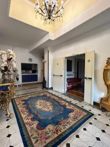 uma sala de estar com um grande tapete no chão em Hotel Petit Royal em Ospedaletti