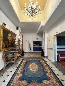 a living room with a rug and a chandelier at Hotel Petit Royal in Ospedaletti