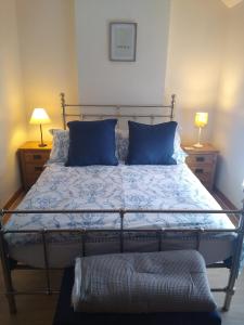 1 dormitorio con 1 cama con almohadas azules en Escape to Anglesey, Dog Friendly en Llangoed