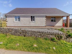 a house with a stone wall in front of it at 3 Bed in Gower 72846 in Port-Eynon