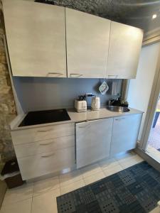 a kitchen with white cabinets and a sink at Apartment in Seborga with a fantastic view in Seborga