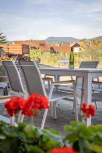 a white table with chairs and a bottle of wine at SARL HARTWEG Les Amandiers in Beblenheim