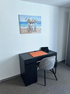 einem schwarzen Schreibtisch mit einem Stuhl und einem Gemälde an der Wand in der Unterkunft Terra Mia Residence in Mugnano di Napoli