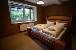 a bedroom with a wooden bed with a window at Hotel Kolonieschänke in Burg