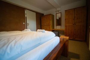 Schlafzimmer mit einem großen weißen Bett und Holzschränken in der Unterkunft Hotel Kolonieschänke in Burg