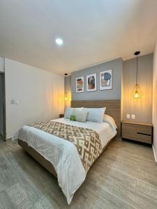 a bedroom with a large bed and two pictures on the wall at Hotel Buena Vista in Bucaramanga