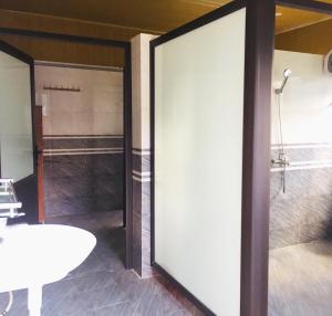 a sliding glass door in a bathroom with a shower at Scenic Views Farmstay And Hostel Sapa in Sa Pả
