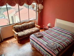 um quarto com uma cama, um sofá e uma janela em Hermosa Habitación en Av Arce frente a Multicine em La Paz