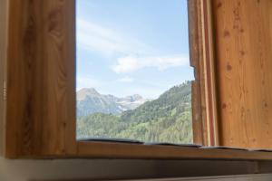 uma janela com vista para uma montanha em Chalet Schmelz Huette mit Sauna und Garten em Flattach