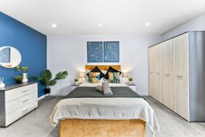 a bedroom with a large bed and blue walls at Beautiful Central Canterbury Apartment - Large Balcony in Kent