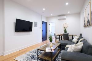 uma sala de estar com um sofá e uma televisão na parede em 7-1 2BR 1Bath in Prime Park Slope em Brooklyn