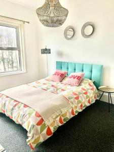Central st Leonard’s Maisonette في سانت ليوناردز: غرفة نوم مع سرير مع وسائد وردية عليه