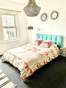 een slaapkamer met een bed met roze kussens erop bij Central st Leonard’s Maisonette in St. Leonards