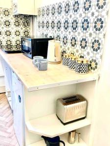聖雷歐納德的住宿－Central st Leonard’s Maisonette，厨房柜台配有微波炉和烤面包机。
